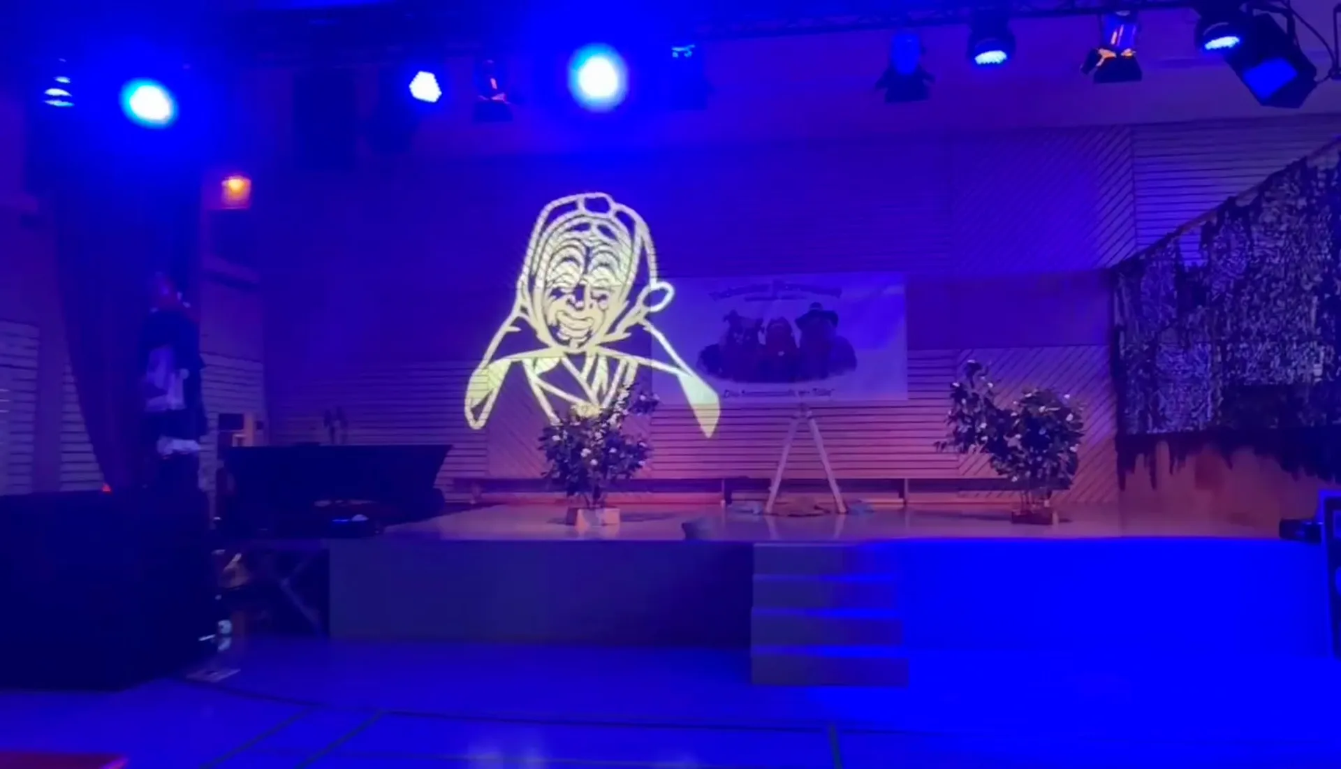 Der fertige Saal: das Maskenmotiv großflächig an der Bühnenwand, Moving Heads auf der Traverse